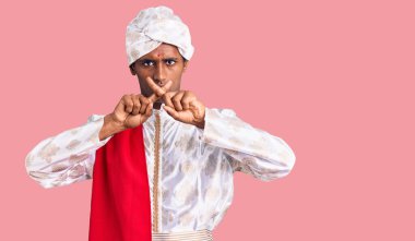 Geleneksel giyinmiş Afrikalı yakışıklı bir adam Sherwani sari elbisesi giymeyi reddediyor. 