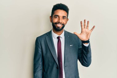 Yakışıklı, sakallı, takım elbiseli ve kravatlı, beş numaralı parmaklarıyla işaret eden, kendinden emin ve mutlu bir adam.. 