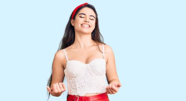 Zarif görünümlü esmer kız çok mutlu ve heyecanlı kolları havada, gülümseyen ve başarı için çığlık atan kazanan bir jest yapıyor. kutlama konsepti. 