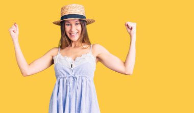 Güzel esmer, yaz şapkası takan genç bir kadın gururla bağırıyor, zaferi ve başarıyı kutluyor. 