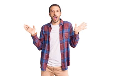 Sıradan kıyafetler giyen genç yakışıklı adam çılgın ve başarıyı kollarını kaldırıp heyecanla haykırarak kutluyor. Kazanan konsept 