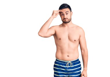 Mayo giyen genç yakışıklı adam endişeli ve stresli. Alnındaki bir sorun yüzünden gergin ve bunalımda. 