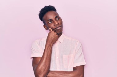 Genç, Afro-Amerikan bir adam, günlük kıyafetler giyiyor ciddi bir yüz ifadesi var, eli çenesinde soru soruyor, kafa karıştırıcı bir fikir. 