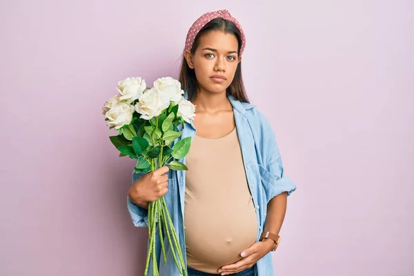 Mulher Hispânica Bonita Esperando Bebê Segurando Flores Relaxado Com Expressão — Fotografia de Stock