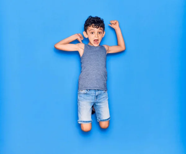 Adorable Niño Con Ropa Casual Saltando Sobre Fondo Azul Aislado — Foto de Stock