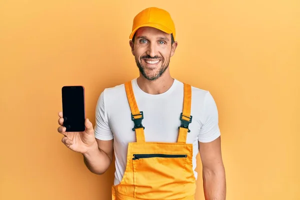 Jovem Homem Bonito Vestindo Uniforme Faz Tudo Mostrando Tela Smartphone — Fotografia de Stock