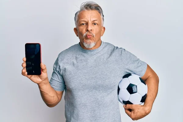 Hombre Pelo Gris Mediana Edad Sosteniendo Pelota Fútbol Mostrando Teléfono — Foto de Stock