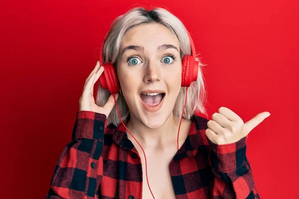 Ung Blond Flicka Lyssnar Musik Med Hörlurar Pekar Tummen Upp — Stockfoto
