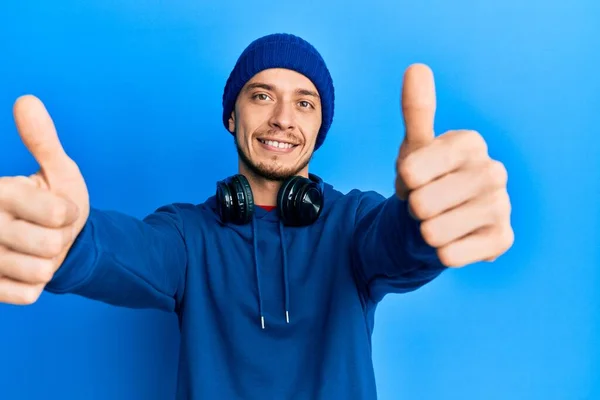 Hispanic Ung Man Bär Tröja Och Hörlurar Godkänner Gör Positiv — Stockfoto