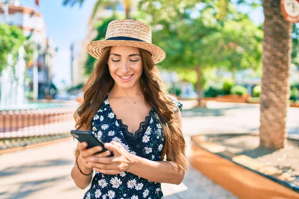 Genç İspanyol kadın şehir caddesinde akıllı telefon kullanıyor..