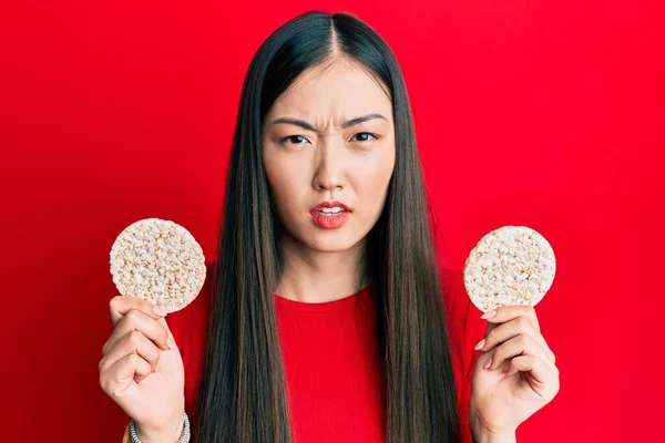 Sağlıklı Pirinç Krakeri Yiyen Genç Çinli Kadın Habersiz Kafası Karışık — Stok fotoğraf