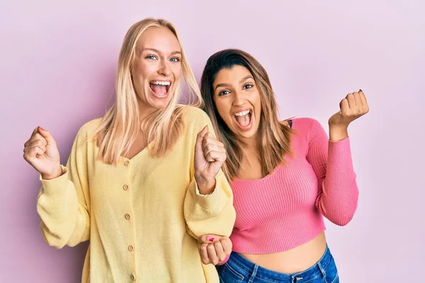 Twee Vrienden Staan Samen Roze Achtergrond Vieren Verrast Verbaasd Voor — Stockfoto