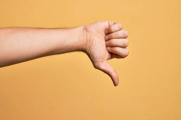 Kafkasyalı Genç Adam Parmaklarını Izole Edilmiş Sarı Arka Planda Gösteriyor — Stok fotoğraf