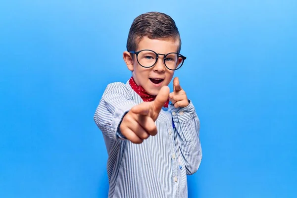 Cute blond kid wearing nerd bow tie and glasses pointing fingers to camera with happy and funny face. good energy and vibes.