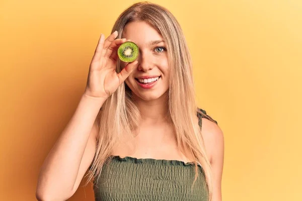 Mladá Blondýna Žena Drží Kiwi Vypadá Pozitivně Šťastně Stojící Usmívá — Stock fotografie