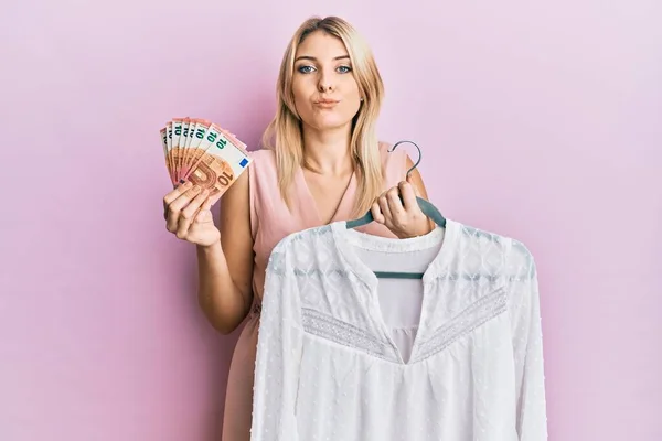 Young Caucasian Woman Holding Hanger Shirt Euro Banknotes Looking Camera — Stock Photo, Image