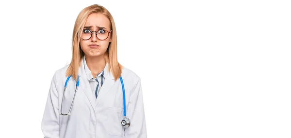 Beautiful Caucasian Woman Wearing Doctor Uniform Stethoscope Puffing Cheeks Funny — Stock Fotó