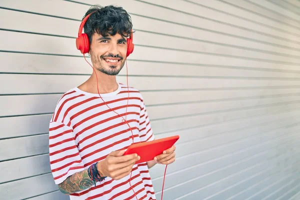 Joven Hombre Hispano Usando Auriculares Touchpad Apoyado Pared Calle Ciudad — Foto de Stock