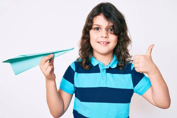 Cute Hispanic Child Long Hair Holding Paper Airplane Smiling Happy — Foto Stock
