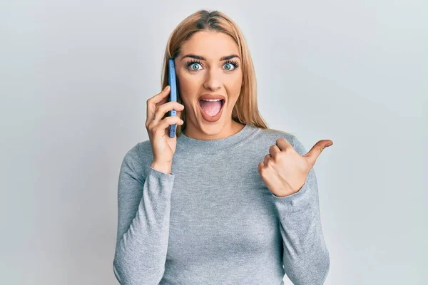 Young Caucasian Woman Having Conversation Talking Smartphone Pointing Thumb Side — Stock Photo, Image