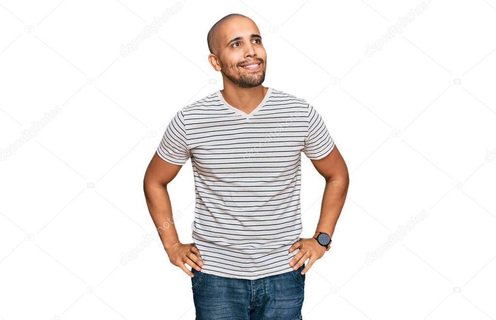 Hispanic adult man wearing casual clothes looking away to side with smile on face, natural expression. laughing confident. 