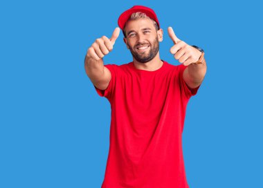 Tişört giyen ve şapka takan genç sarışın adam olumlu bir el hareketi yapıyor, gülümsüyor ve başarı için seviniyor. kazanan jest. 