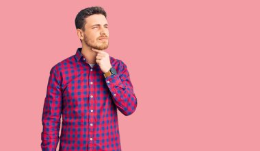 Ayılı yakışıklı genç adam rahat gömleğini giyiyor. Boynuna dokunuyor. Grip, mantar ve enfeksiyon yüzünden boğaz ağrısı çekiyor. 