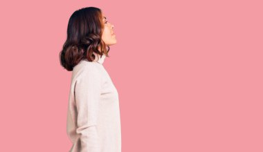 Kış balıkçı yaka kazak giyen genç, güzel bir ırk kadını. Taraf arıyor, profil pozu veriyor, doğal bir yüzü ve kendine güvenen bir gülüşü var.. 