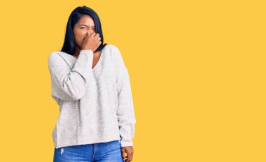 Uzun saçlı, günlük kıyafetler giyen İspanyol kadın pis ve iğrenç bir koku alıyor. Nefesini burnunda tutuyor. Kötü kokuyor. 