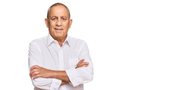 Yakışıklı, beyaz tişörtlü, mutlu yüzlü, kolları çapraz bir şekilde kameraya bakan son sınıf öğrencisi. pozitif kişi. 