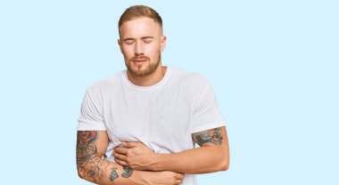 Genç İrlandalı adam midesi üstünde günlük kıyafetler giyiyor çünkü hazımsızlık, acı verici bir hastalık kendini iyi hissetmiyor. Ağrı kavramı. 