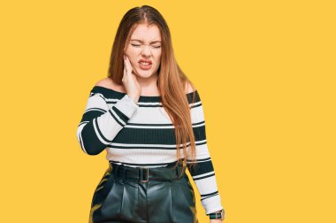 Güzel, güzel, kızıl elbiseli bir kadın diş ağrısı ya da diş ağrısı yüzünden elleriyle dudaklarına dokunuyor. dişçi 