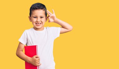 Küçük şirin çocuk kitap okuyor. Parmaklarıyla imza atıyor. Gülümsüyor. 