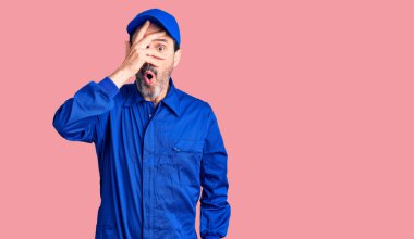 Orta yaşlı, tamirci üniforması giyen yakışıklı bir adam. Şoka girmiş, yüzünü ve gözlerini kapamış, utangaç ifadesiyle parmaklarının arasından bakıyor.. 