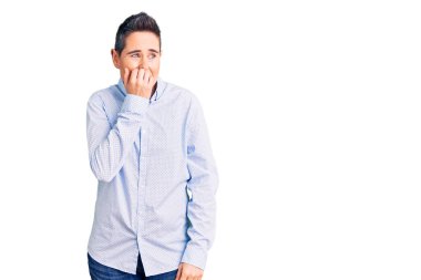 Kısa saçlı, iş kıyafetleri giyen gergin ve gergin görünen elleri ağızdan tırnak yiyen genç bir kadın. anksiyete. 