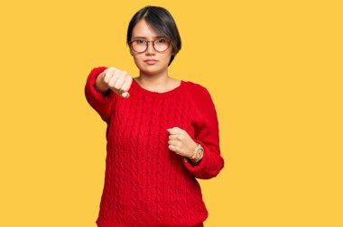 Kısa saçlı, kısa saçlı, gözlüklü, dövüşmek için yumruk atan agresif ve öfkeli saldırı, tehdit ve şiddet dolu genç ve güzel bir İspanyol kadın. 