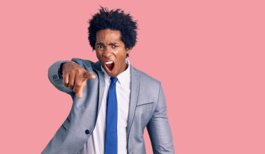 Afro saçlı, iş ceketi giyen yakışıklı Afro-Amerikalı adam kameraya kızgın ve sinirli bir şekilde seni işaret ediyor. 