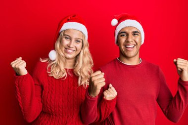 Yılbaşı şapkası takan genç bir çift gururla bağırıyor, zaferi kutluyor ve kollarını kaldırarak başarıyı kutluyor. 