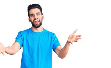 Sakallı, sıradan tişörtlü, neşeli gülümseyen, yardım eli uzatan ve kabul gören genç yakışıklı bir adam.. 