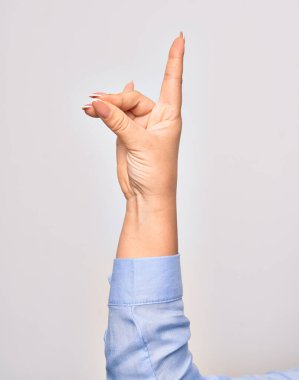 Beyaz arka plan üzerinde gerilmiş işaret parmağıyla yumruk sembolü çizen beyaz bir kadının eli.