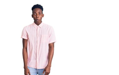 Genç Afro-Amerikan adam günlük kıyafetler giyiyor. Şaşırtıcı bir ifade, korku ve heyecan dolu bir yüz ifadesi var.. 