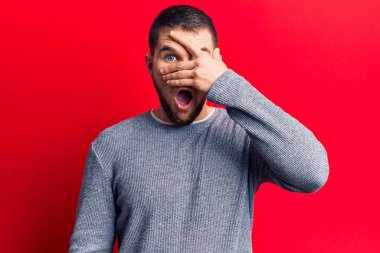 Genç yakışıklı adam, sıradan bir süveter giyiyor. Şoka giriyor, yüzünü ve gözlerini eliyle kapatıyor, parmaklarından bakıyor. 