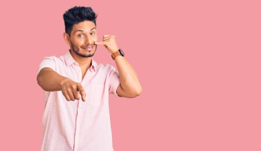 Yakışıklı Latin Amerikalı genç adam rahat bir yaz gömleği giyiyor gülümsüyor telefonda konuşuyor ve seni işaret ediyor. Ara beni.. 