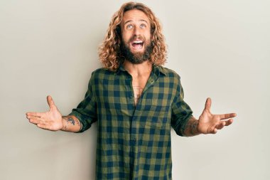 Sakallı, uzun saçlı, sıradan kıyafetler giyen, deli gibi bağıran, agresif ifade ve kollarıyla bağıran yakışıklı bir adam. hüsran kavramı. 