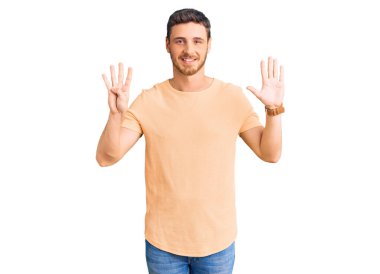 Ayılı yakışıklı genç adam günlük sarı tişört giyiyor ve dokuz numarayı gösteriyor ve gülümsüyor kendinden emin ve mutlu.. 