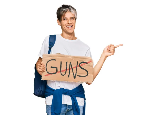 Young Hispanic Man Holding Guns Warning Banner Smiling Happy Pointing — Stock Photo, Image