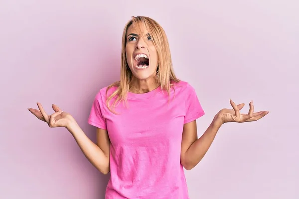 Mulher Loira Bonita Vestindo Camiseta Rosa Casual Louco Louco Gritando — Fotografia de Stock