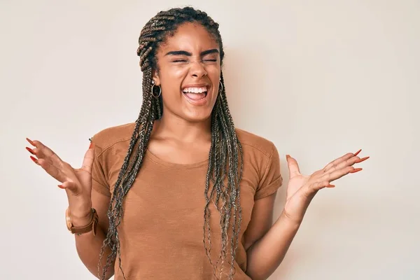 カジュアルな服を着た若いアフリカ系アメリカ人女性が狂気と怒鳴り声を上げ 積極的な表現と腕を上げて叫んでいます フラストレーションコンセプト — ストック写真