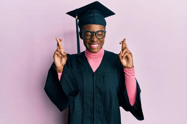 Młoda Afroamerykanka Ubrana Czapkę Dyplomem Szlafrok Gestykulujący Trzymając Kciuki Uśmiechnięta — Zdjęcie stockowe