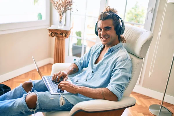 Joven Hombre Hispano Sonriendo Feliz Usando Portátil Auriculares Casa —  Fotos de Stock